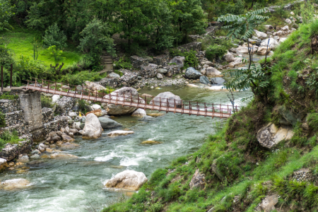 Wooden pedestrian hanging bridge over tirthan river in Tirthan Valley, Himachal Pradesh, India